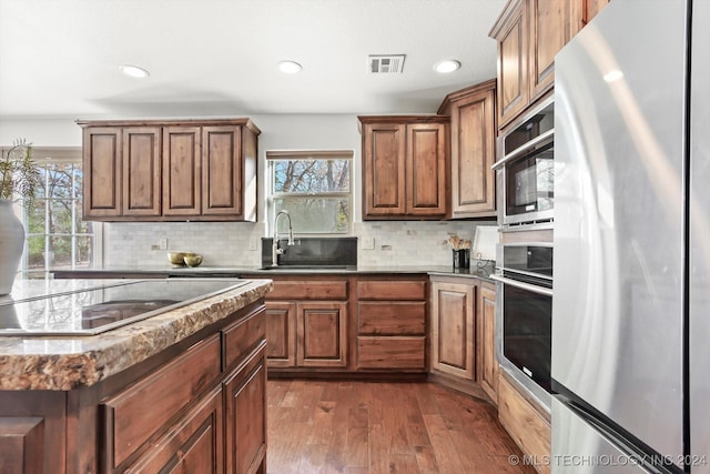 kitchen with decorative backsplash, stainless steel appliances, dark hardwood / wood-style floors, and sink