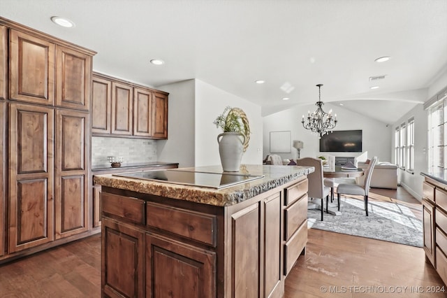 kitchen with a center island, dark wood-type flooring, lofted ceiling, and a notable chandelier