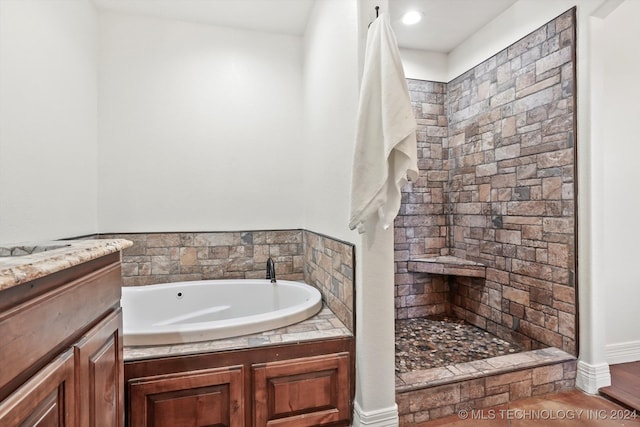 bathroom with wood-type flooring, vanity, and a tub to relax in