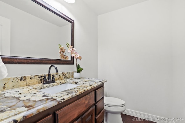 bathroom featuring wood-type flooring, vanity, and toilet