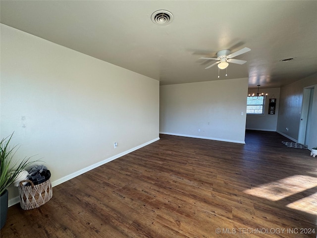 interior space featuring dark wood-type flooring and ceiling fan with notable chandelier