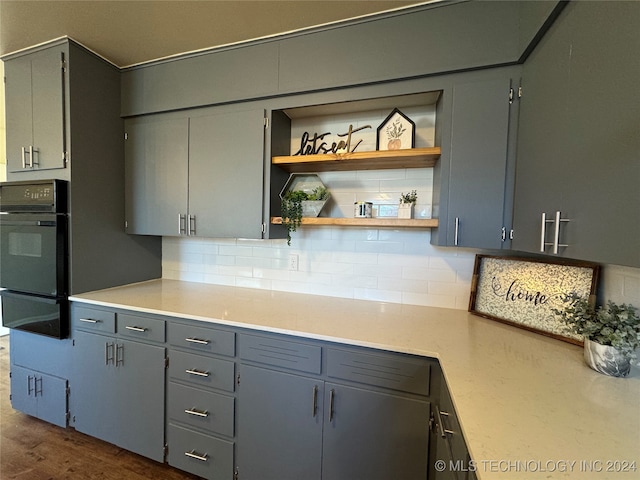 kitchen with dark hardwood / wood-style floors, gray cabinets, and tasteful backsplash