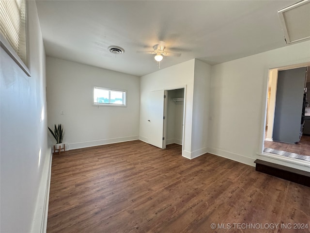 unfurnished bedroom featuring ceiling fan, dark wood-type flooring, and a closet