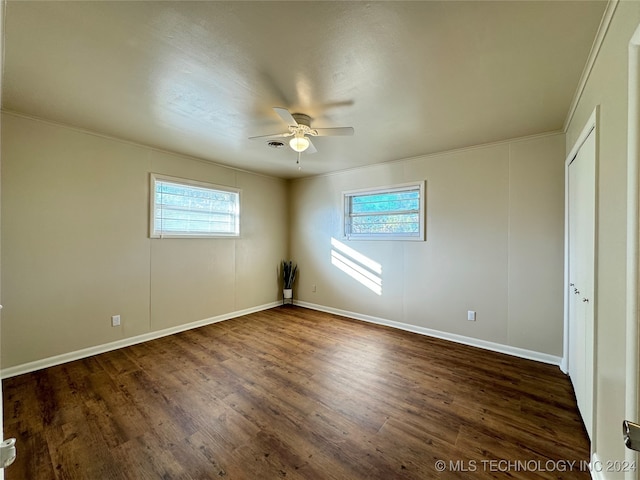 empty room featuring dark hardwood / wood-style floors, ceiling fan, and ornamental molding