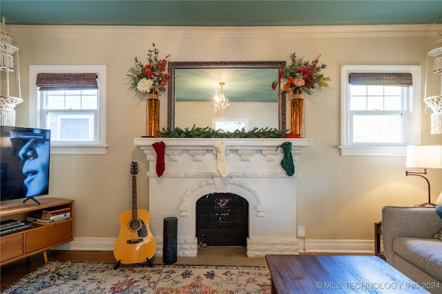 living room featuring hardwood / wood-style flooring, ornamental molding, a fireplace, and a wealth of natural light