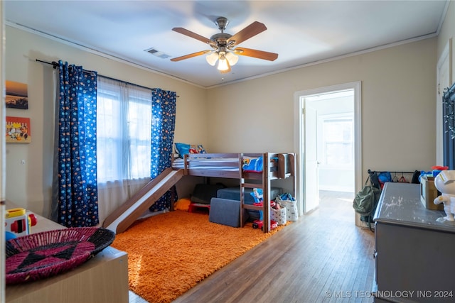 bedroom with ceiling fan, wood-type flooring, and ornamental molding