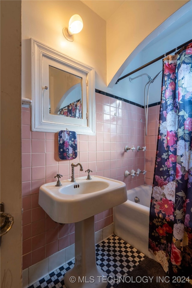 bathroom with tile patterned floors, shower / tub combo, and tile walls