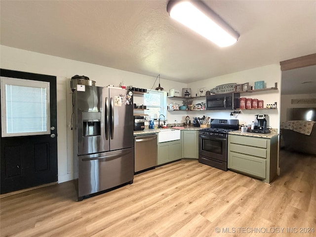 kitchen featuring black appliances, light wood-type flooring, a textured ceiling, and green cabinetry