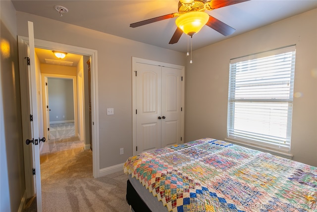 carpeted bedroom featuring ceiling fan and a closet