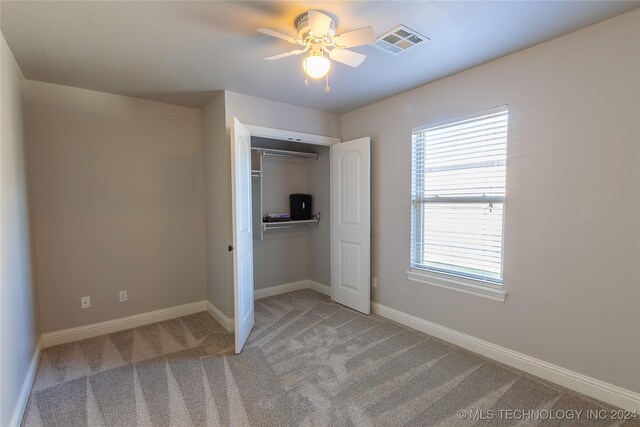 unfurnished bedroom with carpet, ceiling fan, and a closet