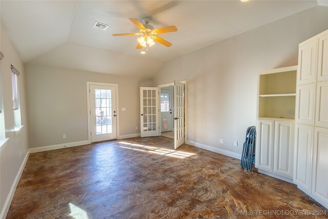 empty room featuring built in shelves, ceiling fan, french doors, and lofted ceiling