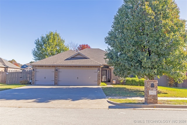 view of front of home with a front lawn and a garage