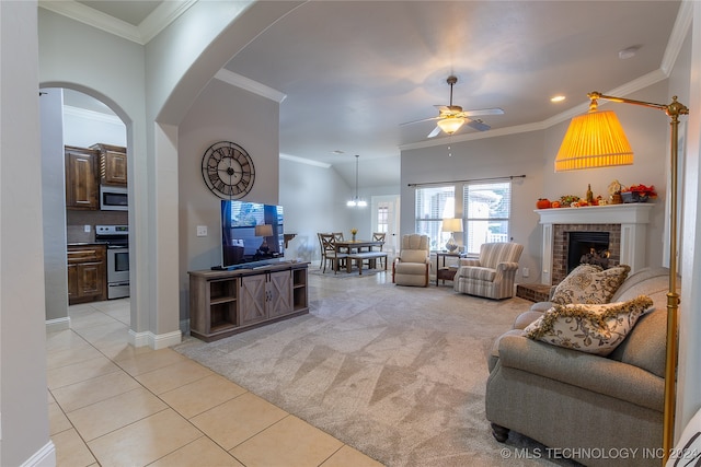 living room with ceiling fan, light colored carpet, ornamental molding, and a fireplace