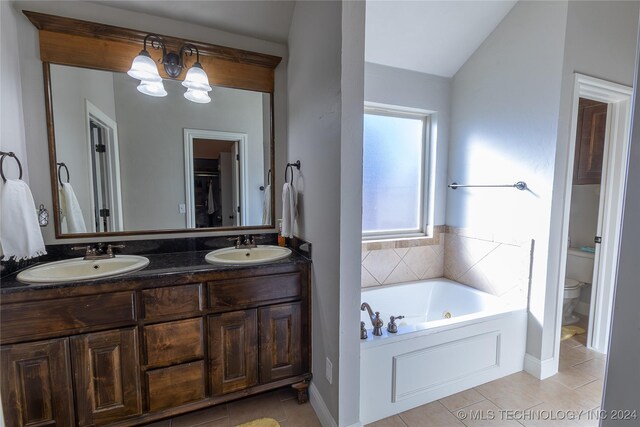 bathroom with tile patterned floors, vanity, toilet, and vaulted ceiling