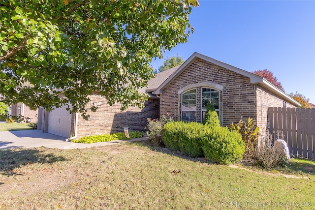 view of front of home with a front yard and a garage