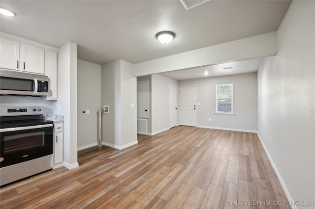 kitchen with white cabinetry, stainless steel appliances, and light hardwood / wood-style flooring