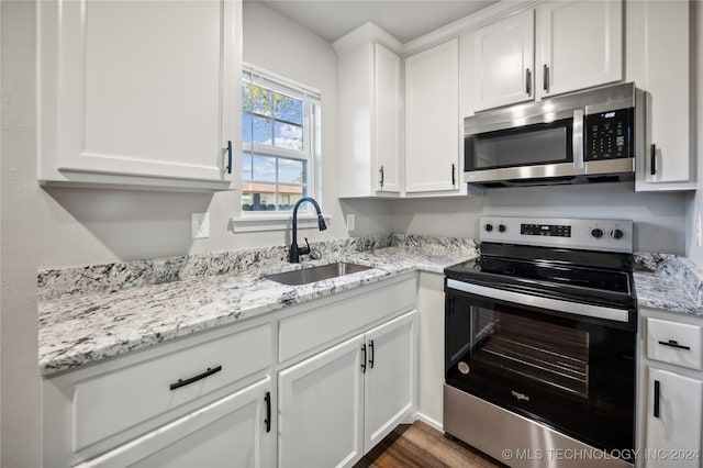 kitchen featuring white cabinets, sink, light stone counters, dark hardwood / wood-style flooring, and stainless steel appliances