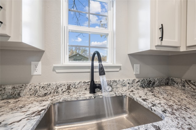 details featuring white cabinetry, sink, and light stone counters