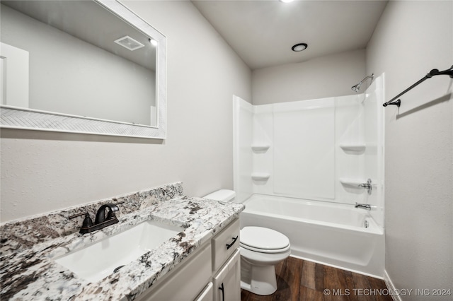 full bathroom featuring bathtub / shower combination, vanity, hardwood / wood-style flooring, and toilet