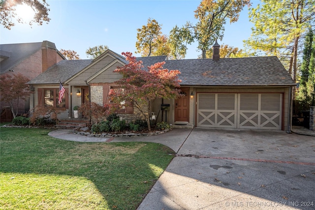 view of front of property featuring a garage and a front lawn