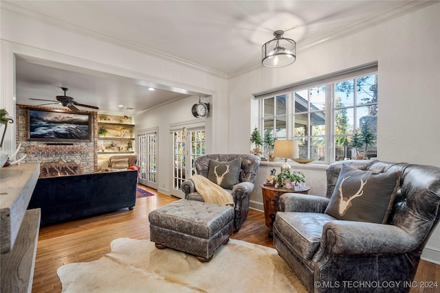 living room featuring hardwood / wood-style flooring, a wealth of natural light, crown molding, and ceiling fan