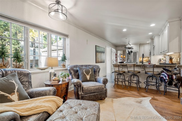 living room with light hardwood / wood-style flooring and crown molding