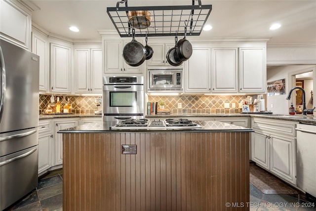 kitchen with white cabinets, a center island, stainless steel appliances, and sink