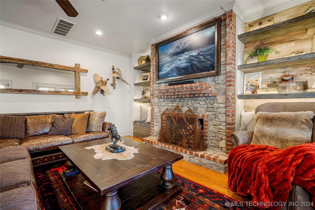 living room with a brick fireplace, hardwood / wood-style floors, and ornamental molding