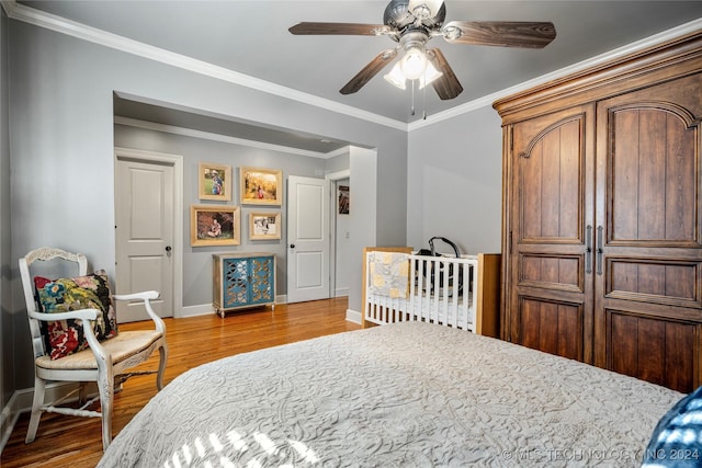 bedroom featuring hardwood / wood-style floors, ceiling fan, and ornamental molding