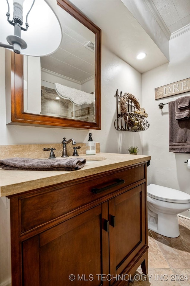 bathroom featuring vanity, toilet, and ornamental molding