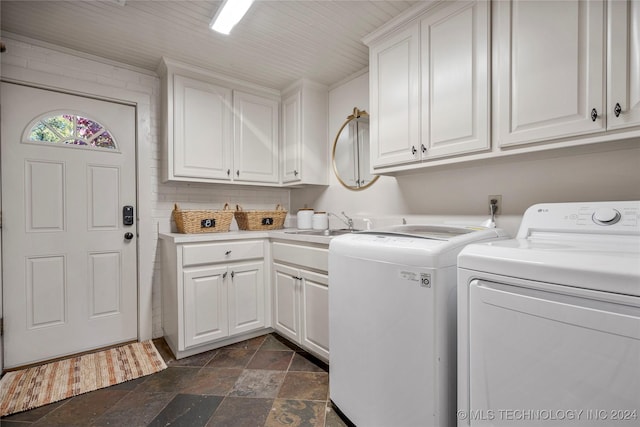 laundry area featuring washing machine and dryer, sink, and cabinets