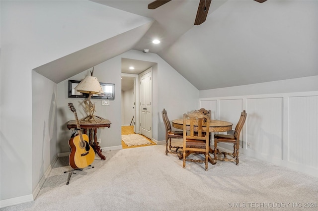 dining room featuring ceiling fan, light carpet, and vaulted ceiling