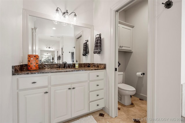 bathroom with tile patterned flooring, vanity, and toilet