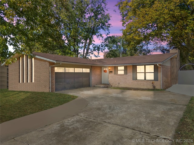 ranch-style home featuring a yard and a garage