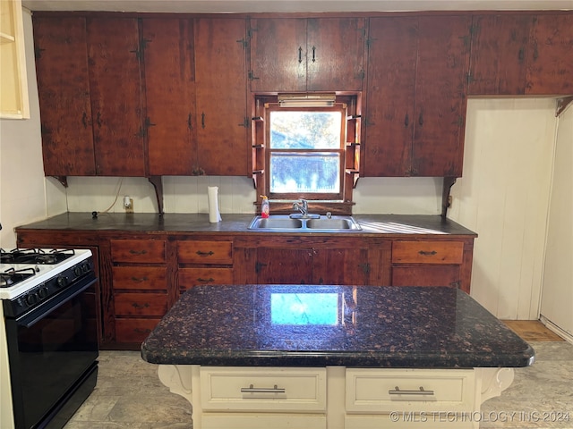 kitchen with sink, white gas range oven, and dark stone counters