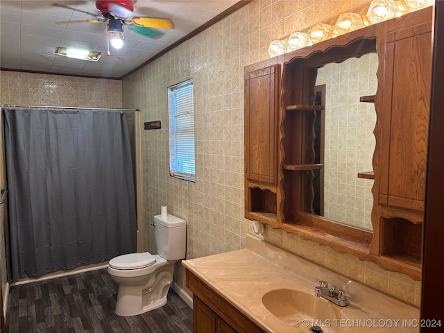 full bathroom with hardwood / wood-style floors, vanity, crown molding, toilet, and tile walls