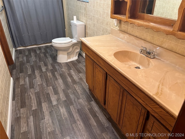 bathroom with a shower with curtain, toilet, vanity, tile walls, and hardwood / wood-style flooring