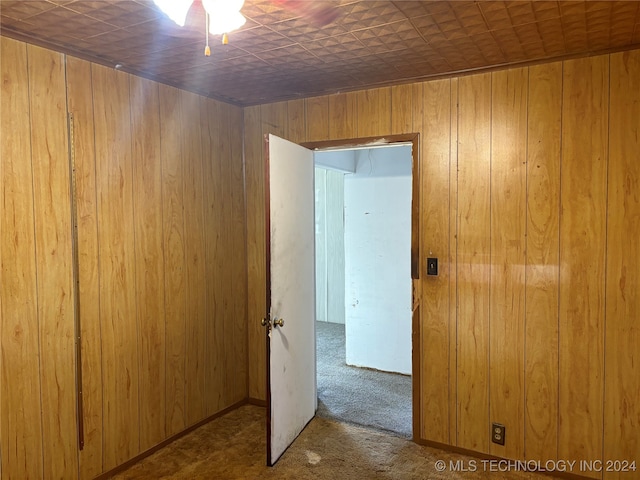 carpeted empty room with wooden walls