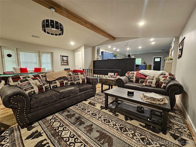 living room with plenty of natural light and vaulted ceiling with beams