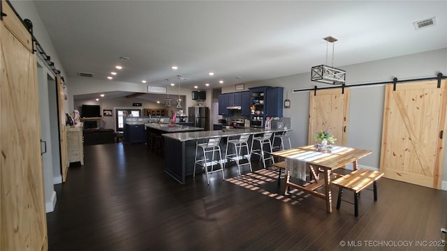 dining room featuring dark hardwood / wood-style flooring and a barn door