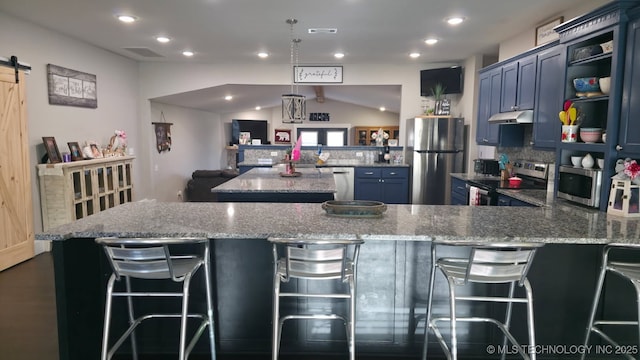 kitchen with stainless steel appliances, a barn door, light stone countertops, and blue cabinets