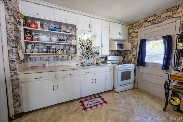 kitchen featuring decorative backsplash, white cabinetry, sink, and white range with gas cooktop