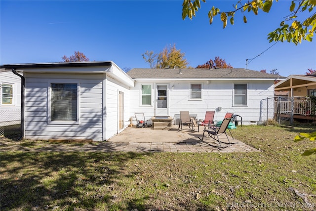 back of property with a patio area and a lawn