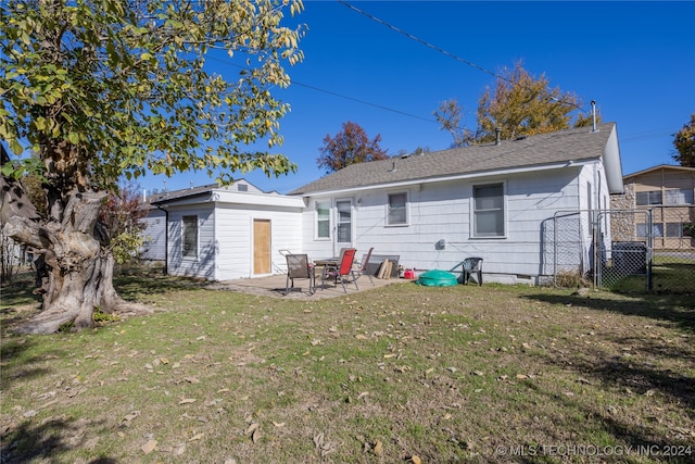 rear view of house with a yard and a patio area