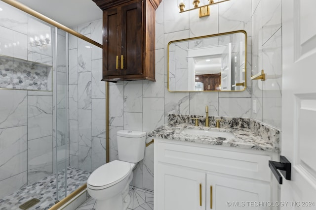 bathroom featuring vanity, a shower with shower door, tile walls, and toilet