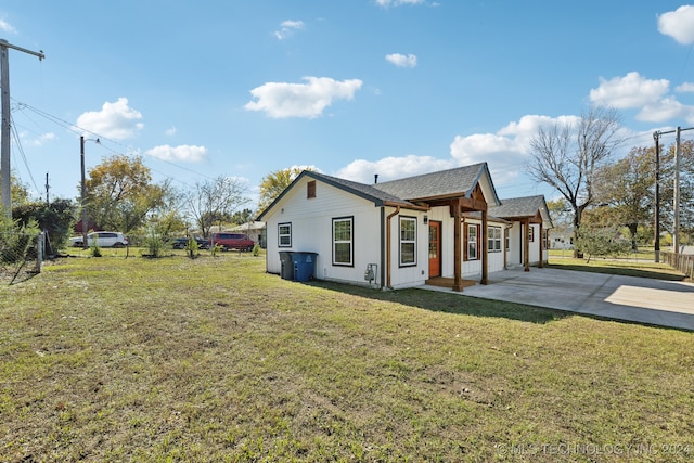 view of side of property with a yard and a patio area