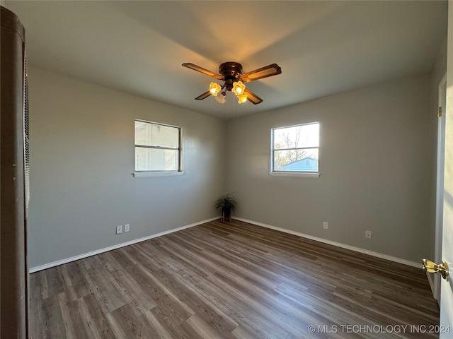 empty room with ceiling fan and dark hardwood / wood-style flooring