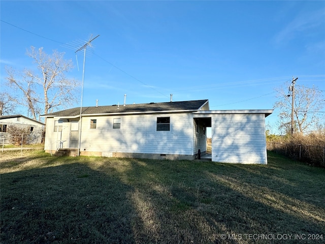 rear view of house featuring a lawn