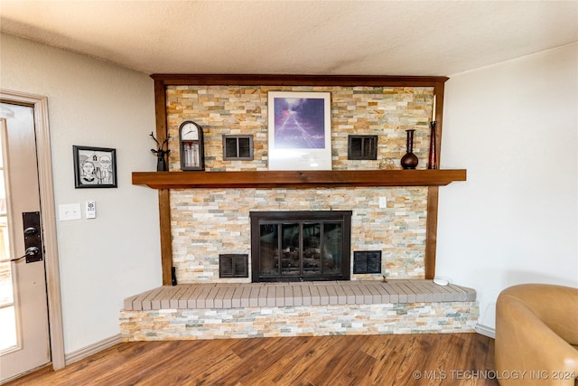 room details featuring a fireplace, a textured ceiling, and hardwood / wood-style flooring