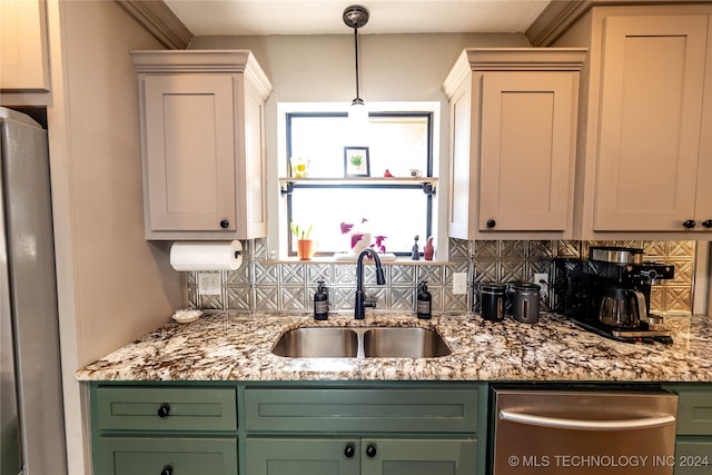 kitchen featuring light stone countertops, sink, tasteful backsplash, appliances with stainless steel finishes, and green cabinetry